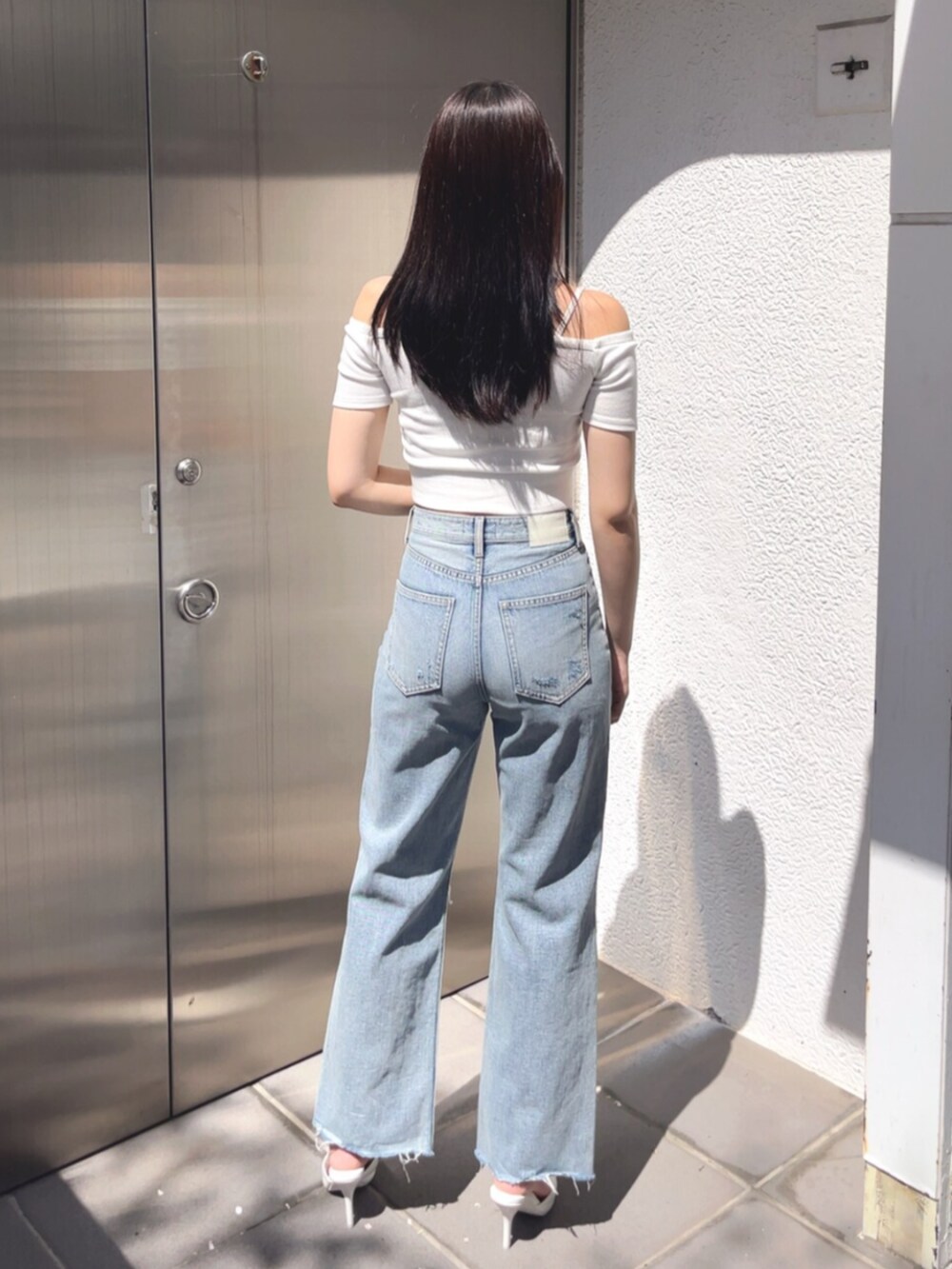 ホワイト系のパンプス、ブルー系のデニムパンツ、ホワイト系のTシャツ/カットソーを着用したレディースの春コーディネートの3枚目の写真