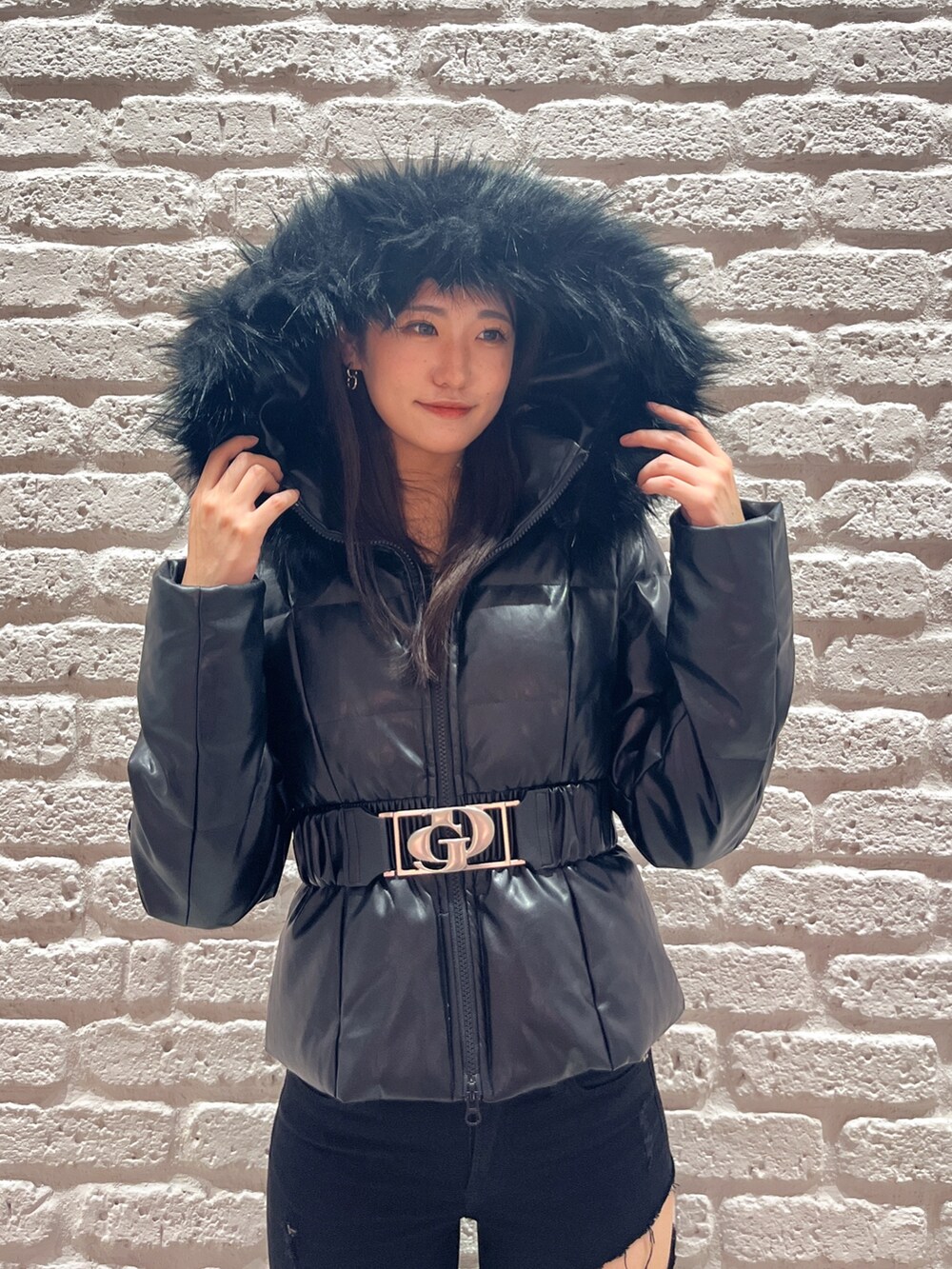 ブラック系のデニムパンツ、ブラック系のダウンジャケット/コート、ブラック系のブーツを着用したレディースの秋コーディネートの4枚目の写真