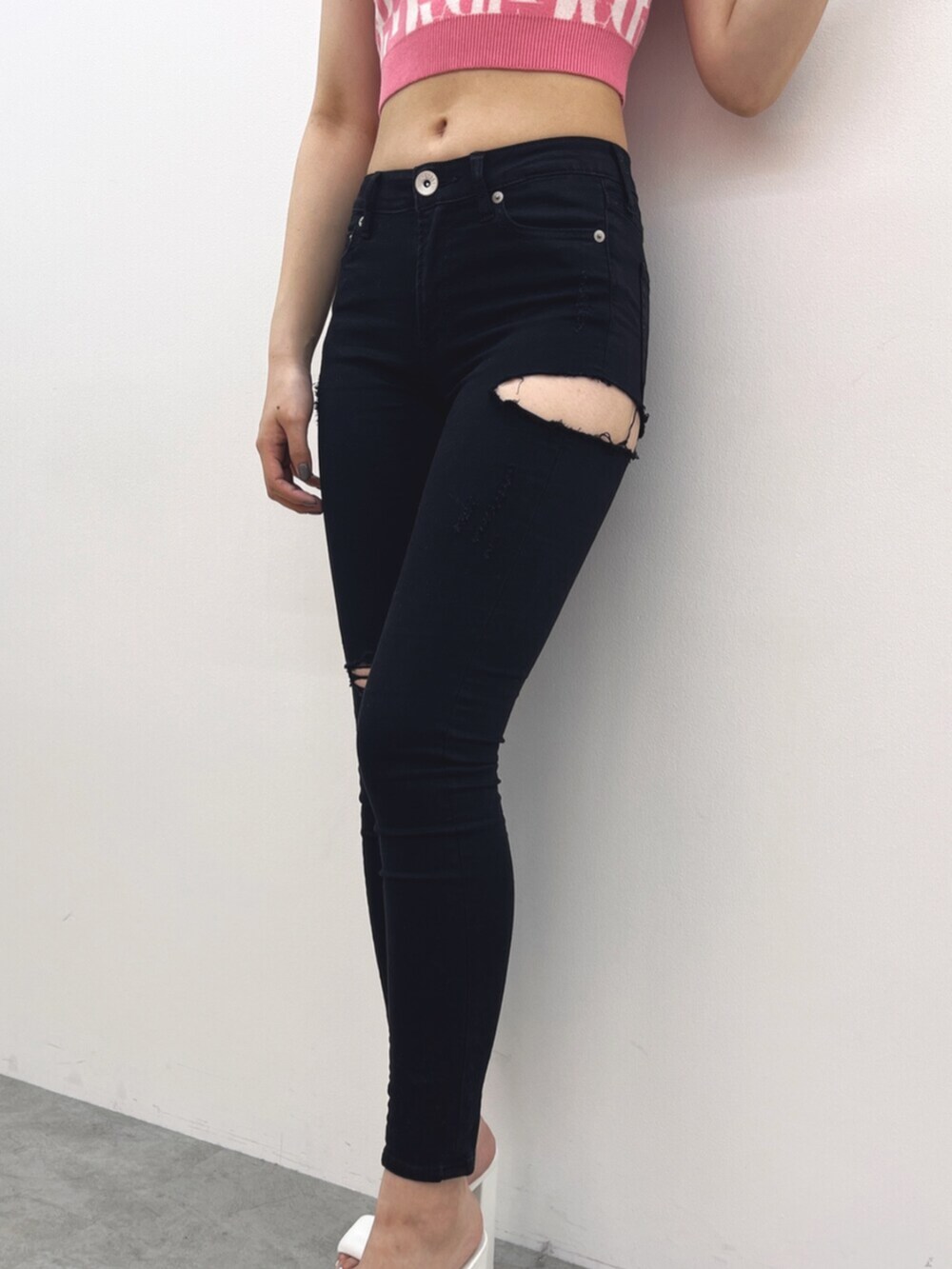 ブラック系のデニムパンツ、ピンク系のニット/セーター、ホワイト系のサンダルを着用したレディースの春コーディネートの4枚目の写真