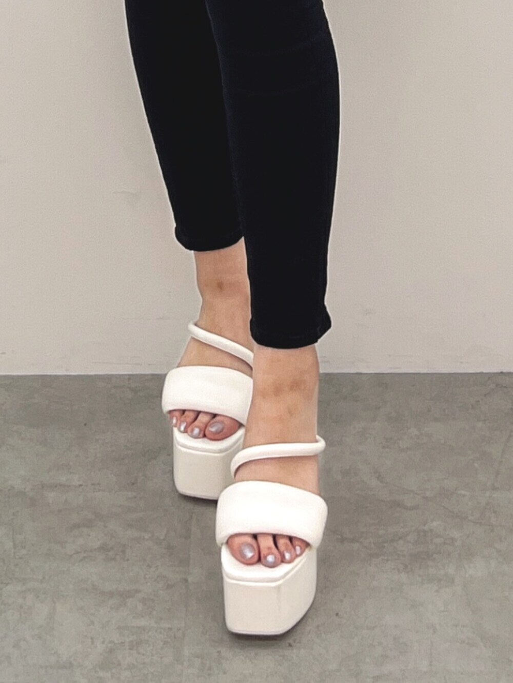 ブラック系のデニムパンツ、ピンク系のニット/セーター、ホワイト系のサンダルを着用したレディースの春コーディネートの5枚目の写真