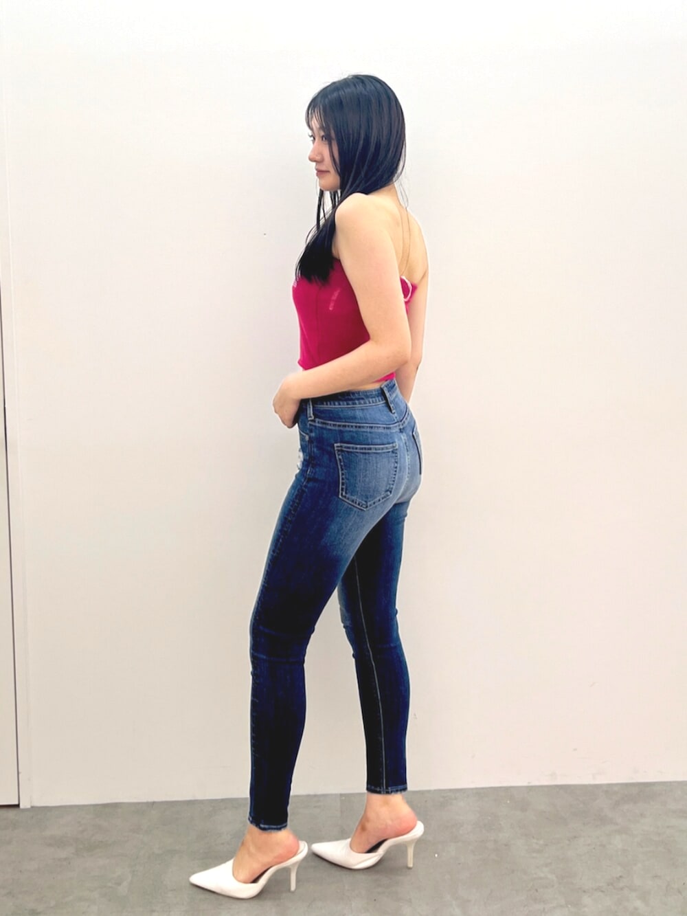 ホワイト系のパンプス、ブルー系のデニムパンツ、ピンク系のニット/セーターを着用したレディースの夏コーディネートの2枚目の写真