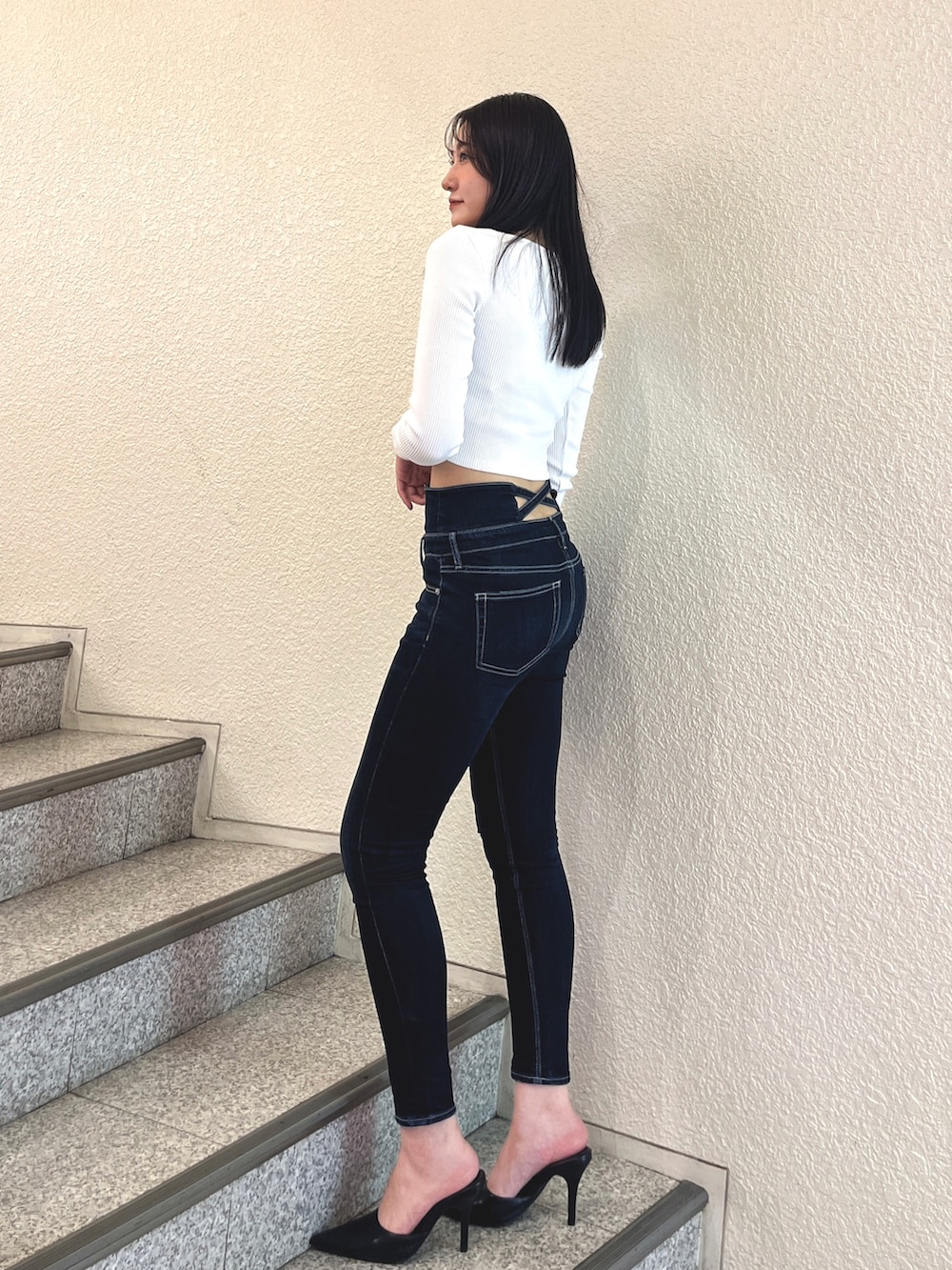 ブルー系のデニムパンツ、ブラック系のパンプス、ホワイト系のTシャツ/カットソーを着用したレディースの春コーディネートの2枚目の写真