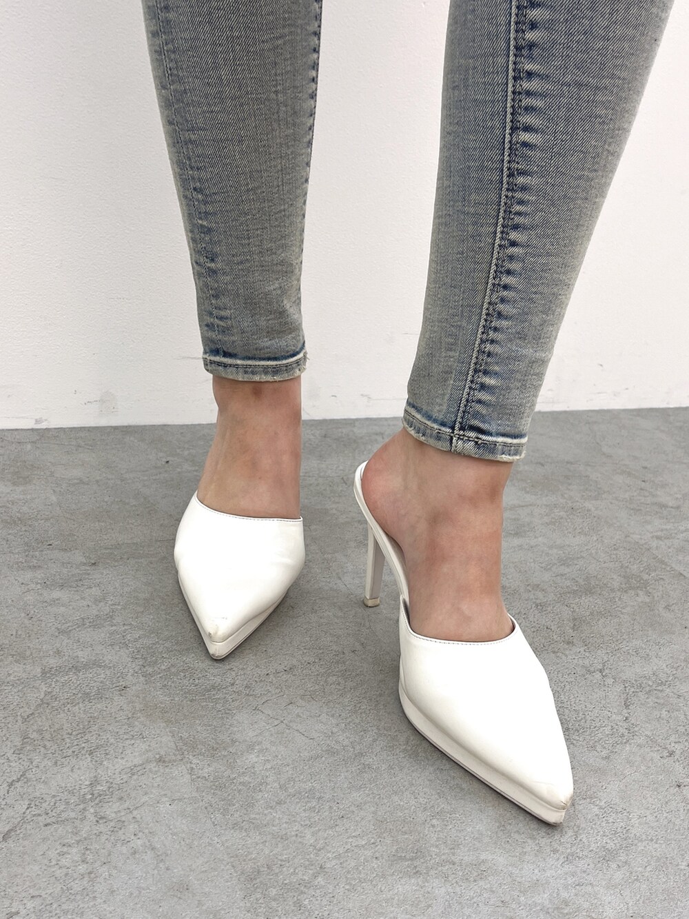 ブルー系のデニムパンツ、ホワイト系のパンプス、その他のニット/セーターを着用したレディースの春コーディネートの4枚目の写真