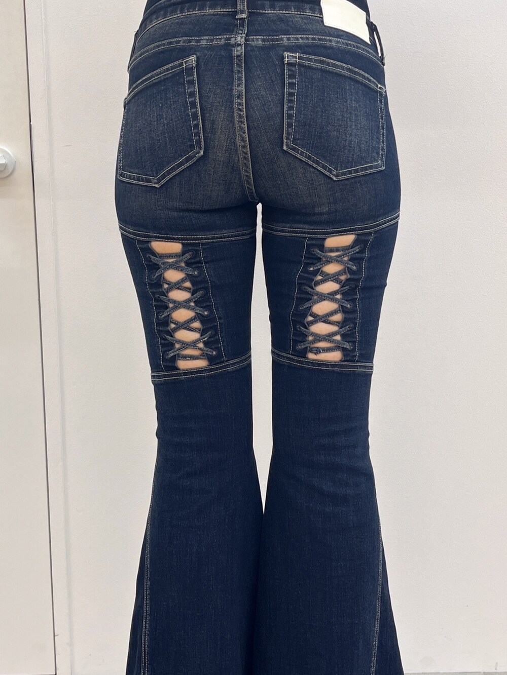 ブラック系のブーツ、シルバー系のニット/セーター、ブルー系のデニムパンツを着用したレディースの秋コーディネートの5枚目の写真