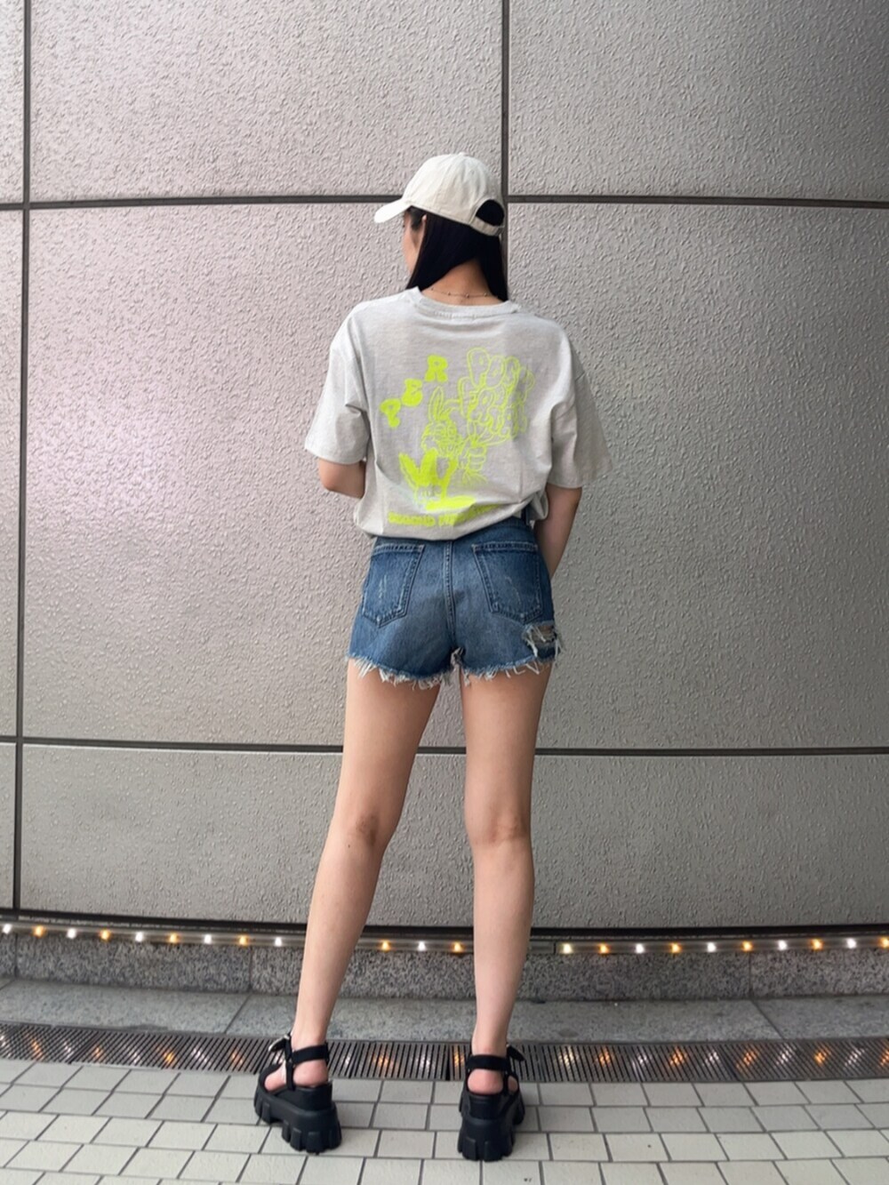 ブルー系のデニムパンツ、グレー系のTシャツ/カットソー、ブラック系のサンダルを着用したレディースの春コーディネートの3枚目の写真
