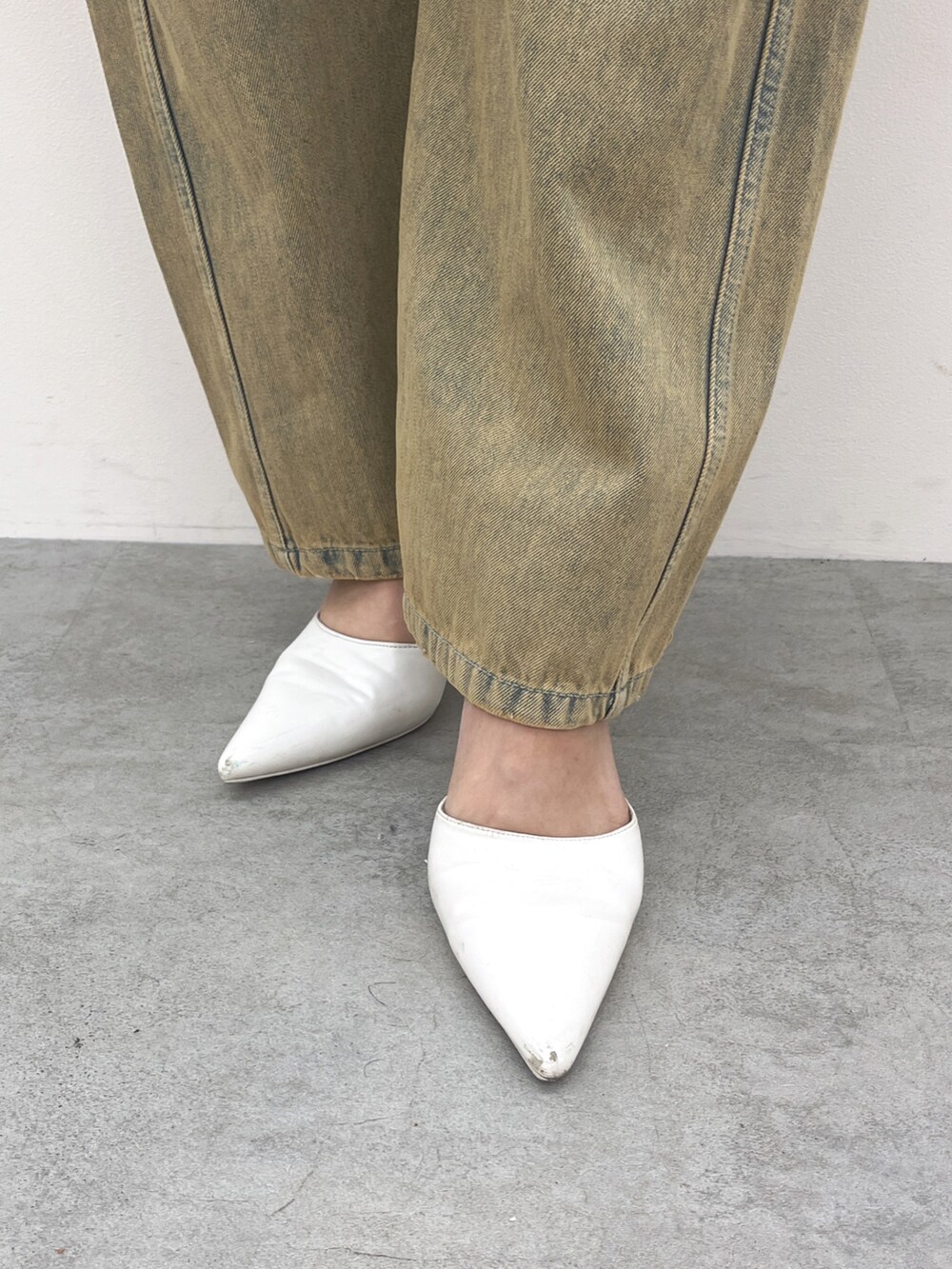 ホワイト系のタンクトップ、ブルー系のデニムパンツ、ホワイト系のパンプスを着用したレディースの夏コーディネートの4枚目の写真