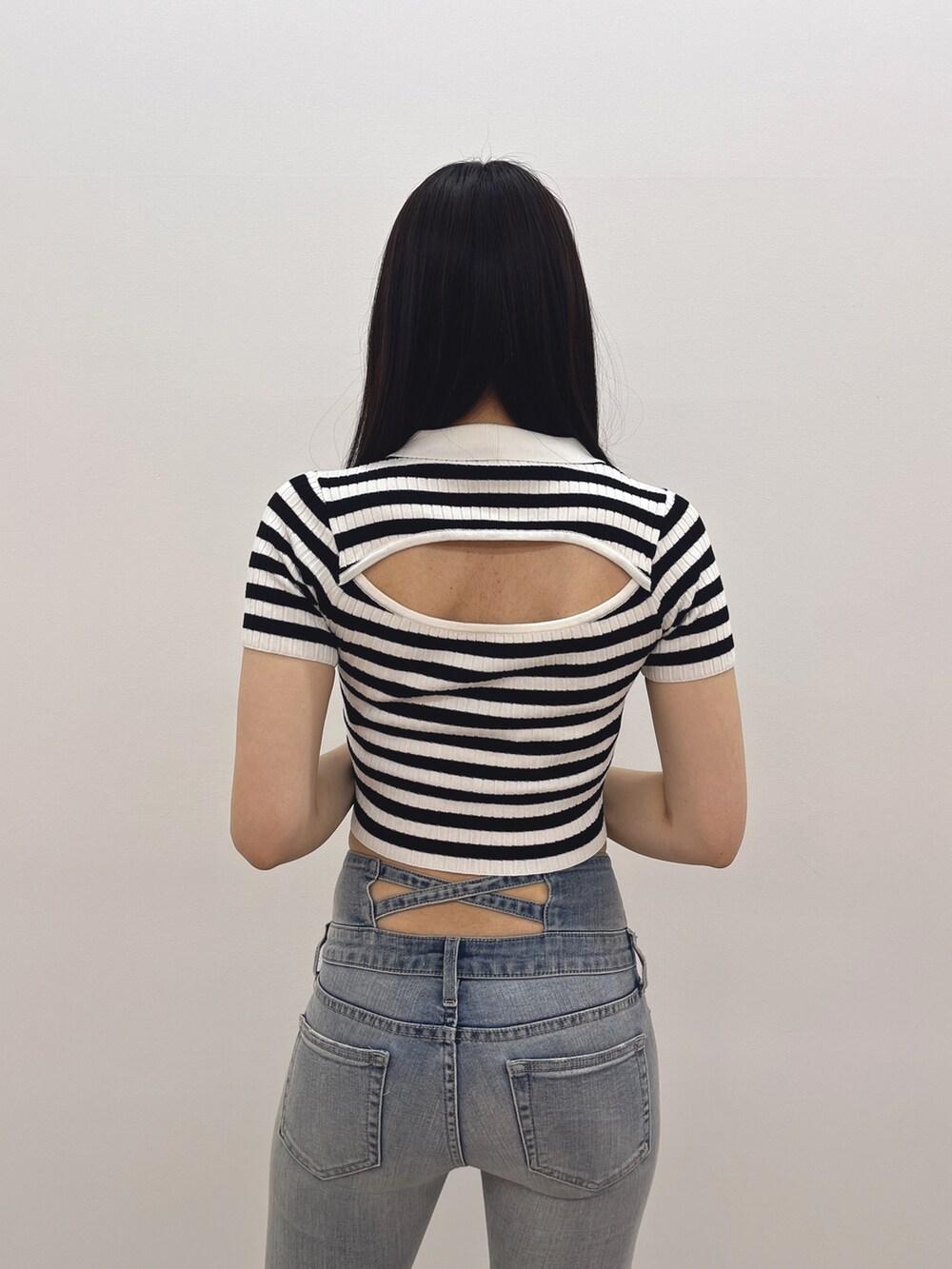 ブルー系のデニムパンツ、ホワイト系のパンプス、その他のニット/セーターを着用したレディースの春コーディネートの5枚目の写真