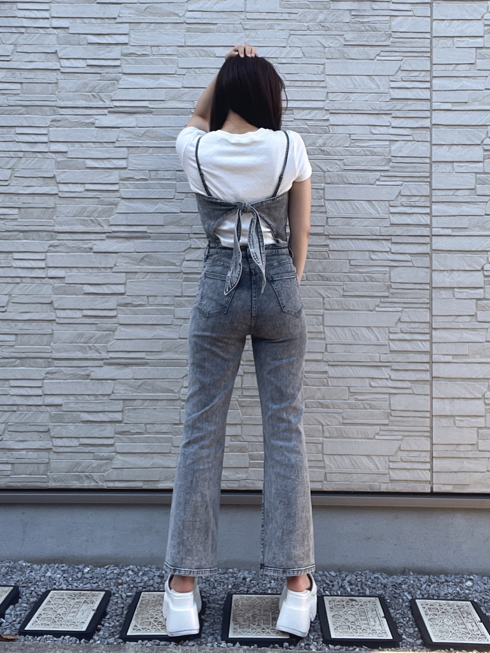 ブラック系のサロペット/オーバーオール、ホワイト系のサンダル、ホワイト系のTシャツ/カットソーを着用したレディースの夏コーディネートの3枚目の写真