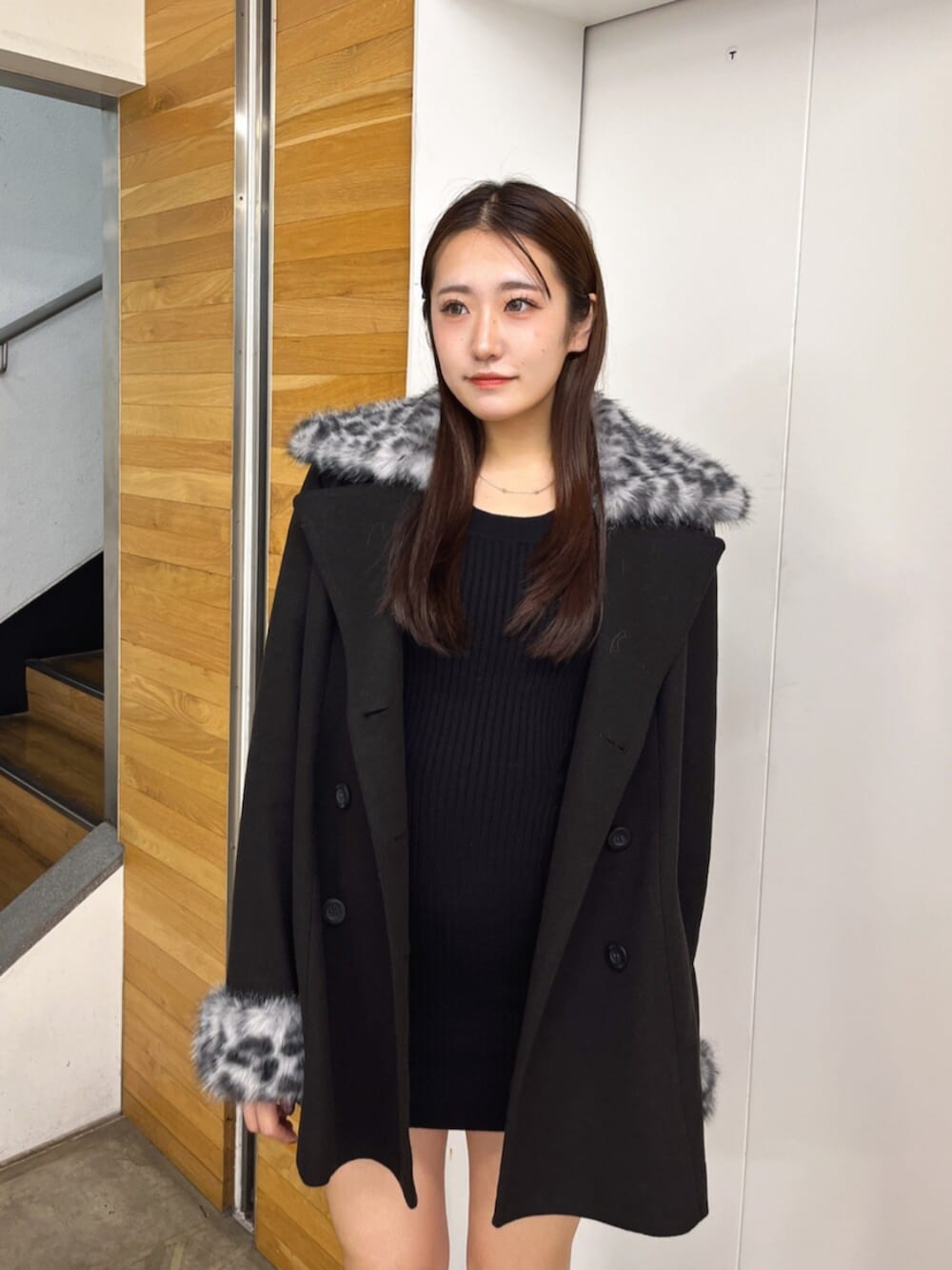 ブラック系のブーツ、ブラック系のワンピース、ブラック系のチェスターコートを着用したレディースの秋コーディネートの4枚目の写真