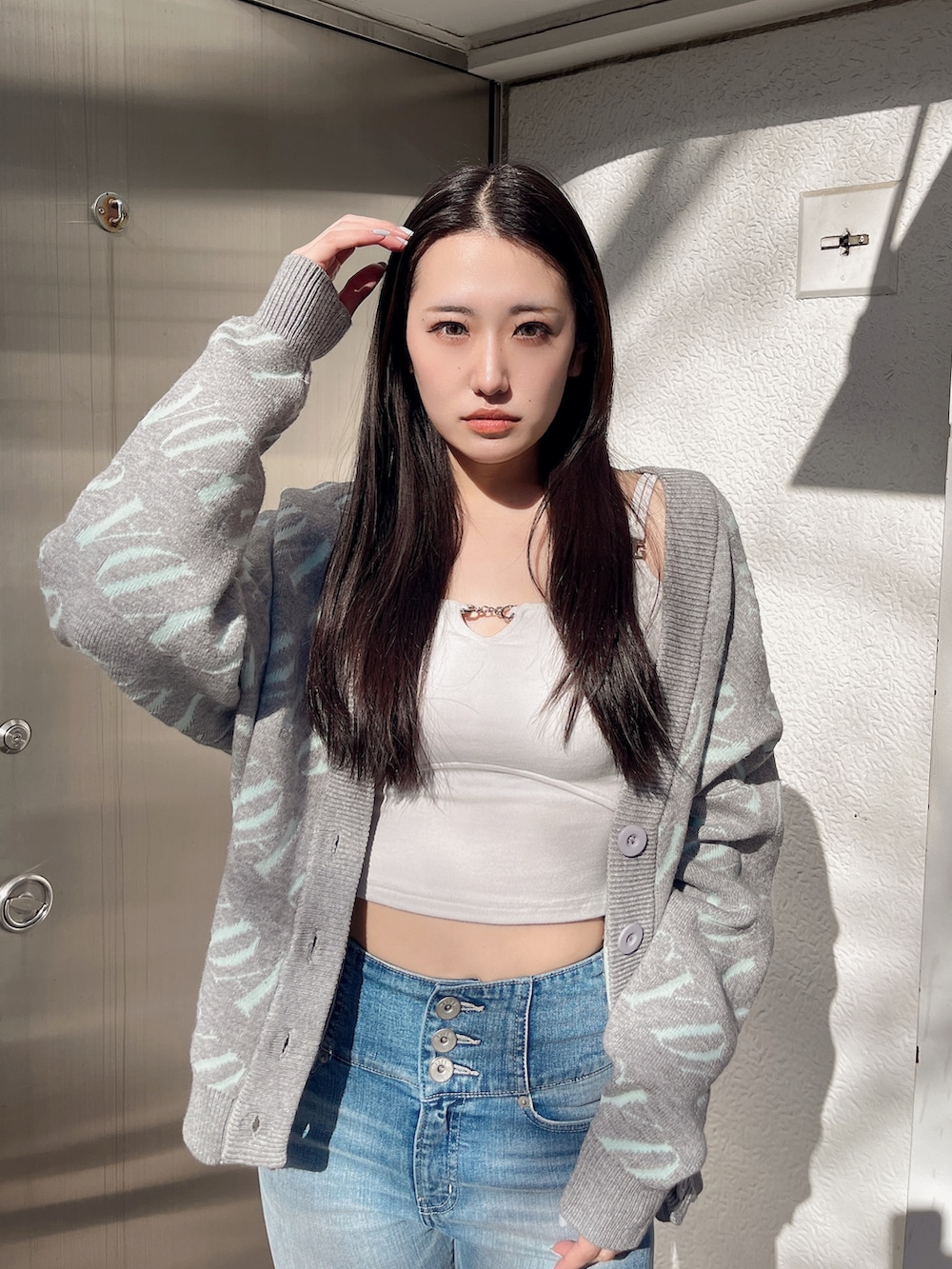 ホワイト系のTシャツ/カットソー、グレー系のカーディガン/ボレロ、ブルー系のデニムパンツを着用したレディースの冬コーディネートの5枚目の写真