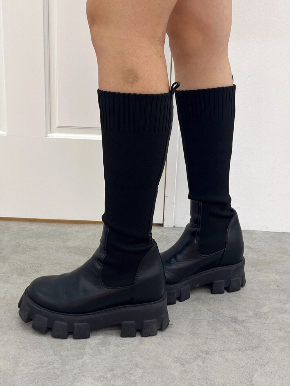 ブラック系のブーツ、ブラック系のデニムスカート、グレー系のTシャツ/カットソーを着用したレディースの秋コーディネートの5枚目の写真