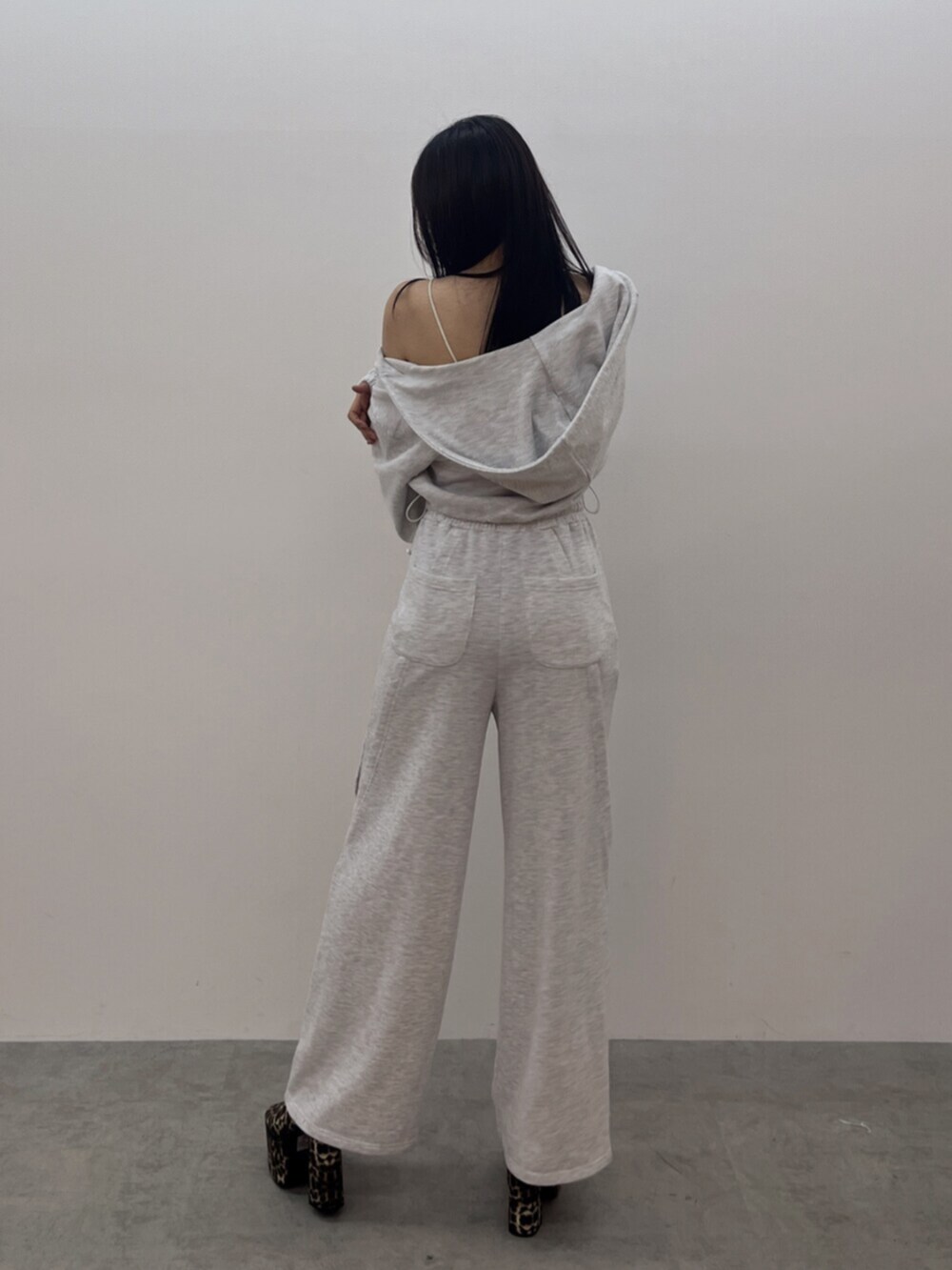 ホワイト系のキャミソール、グレー系のパーカー、グレー系のスウェットパンツを着用したレディースの春コーディネートの3枚目の写真