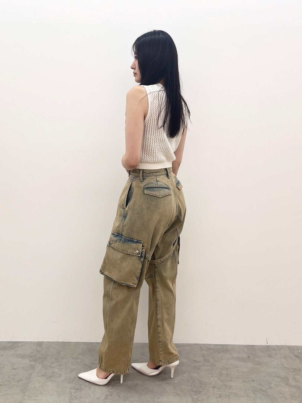 ホワイト系のタンクトップ、ブルー系のデニムパンツ、ホワイト系のパンプスを着用したレディースの夏コーディネートの2枚目の写真