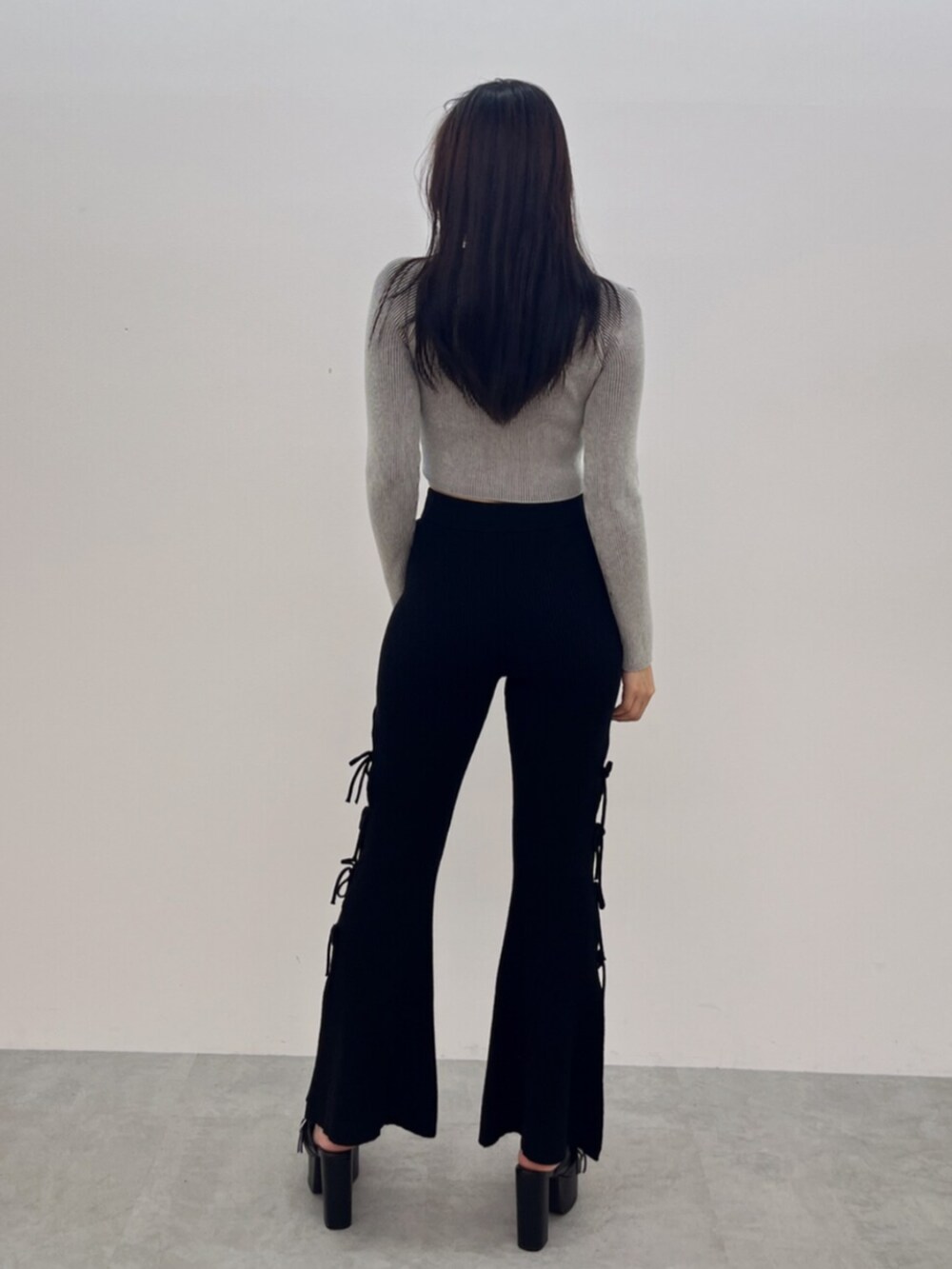 ブラック系のサンダル、ホワイト系のニット/セーター、ブラック系のその他パンツを着用したレディースの夏コーディネートの3枚目の写真