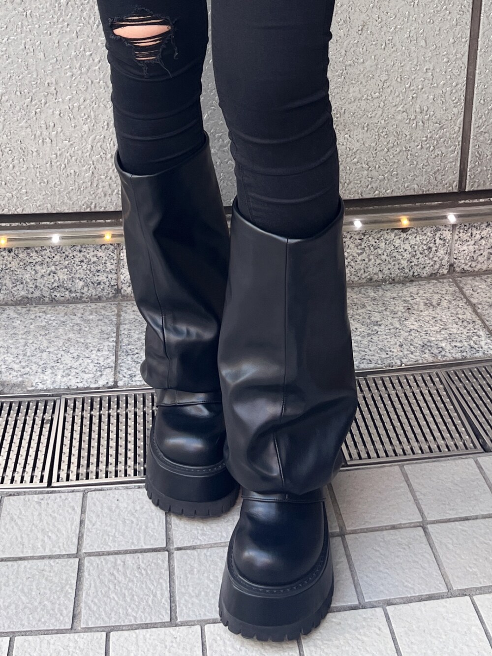 ブラック系のデニムパンツ、ブラック系のダウンジャケット/コート、ブラック系のブーツを着用したレディースの秋コーディネートの5枚目の写真