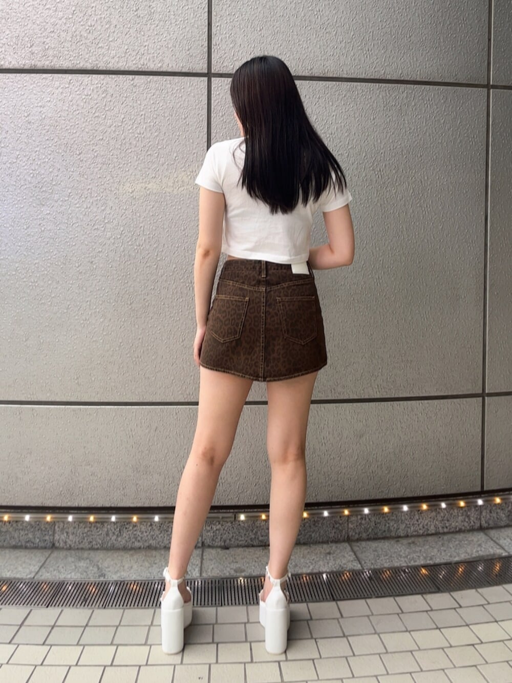 ホワイト系のTシャツ/カットソー、ブラウン系のスカート、ホワイト系のサンダルを着用したレディースの夏コーディネートの3枚目の写真