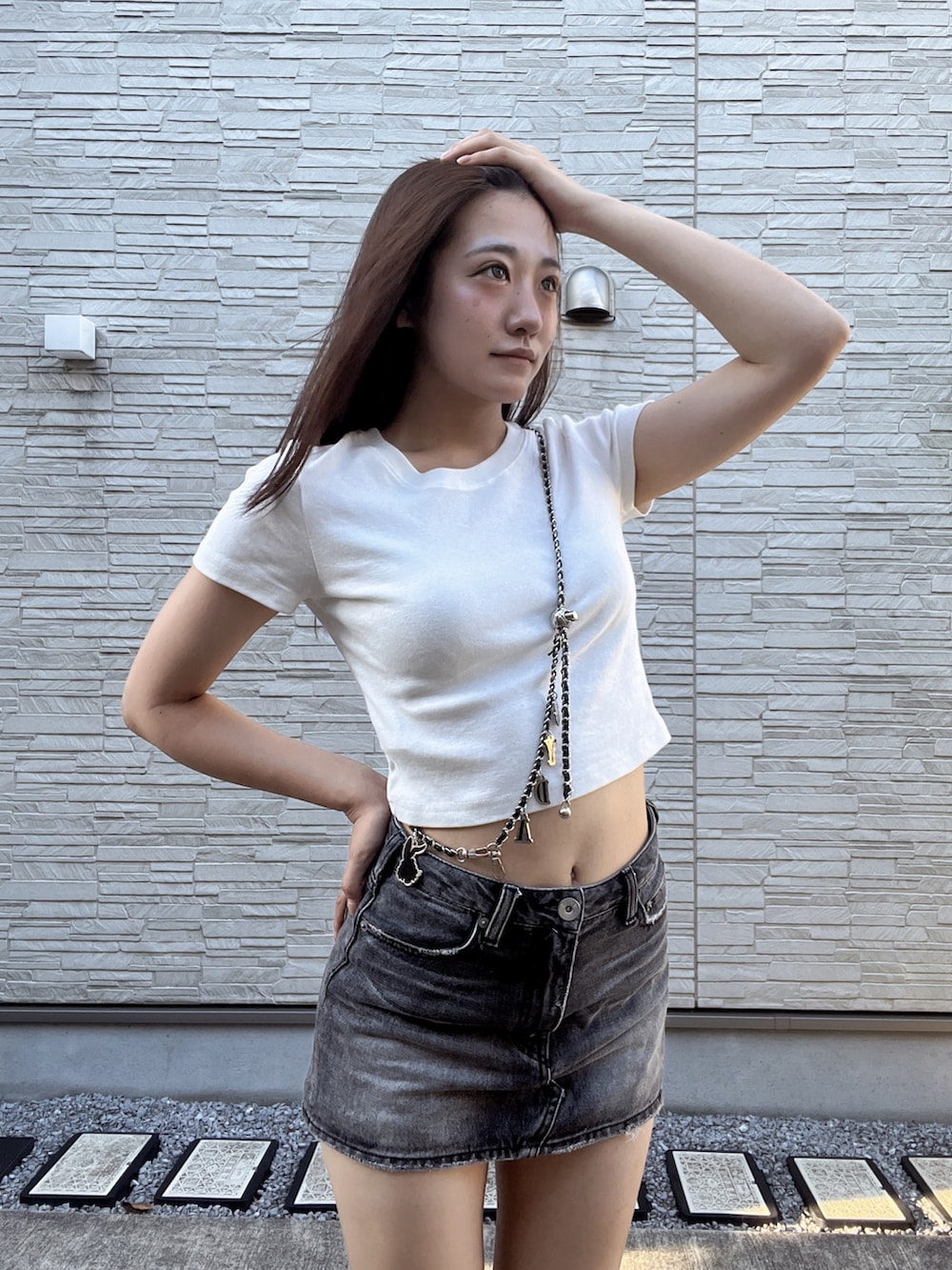 ホワイト系のTシャツ/カットソー、ブラック系のデニムスカート、ホワイト系のサンダルを着用したレディースの夏コーディネートの5枚目の写真