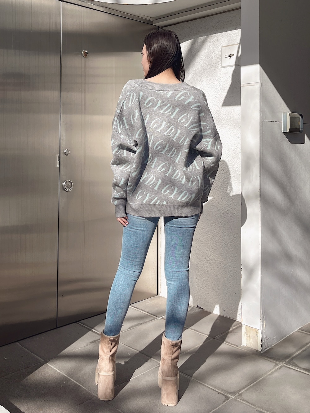 ホワイト系のTシャツ/カットソー、グレー系のカーディガン/ボレロ、ブルー系のデニムパンツを着用したレディースの冬コーディネートの3枚目の写真