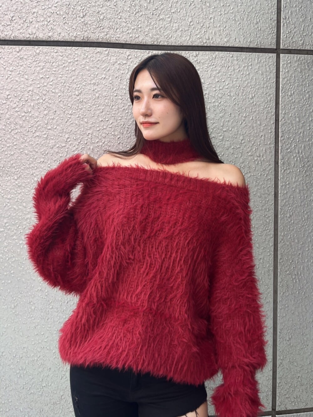 ブラック系のデニムパンツ、ブラック系のブーツ、レッド系のニット/セーターを着用したレディースの秋コーディネートの5枚目の写真