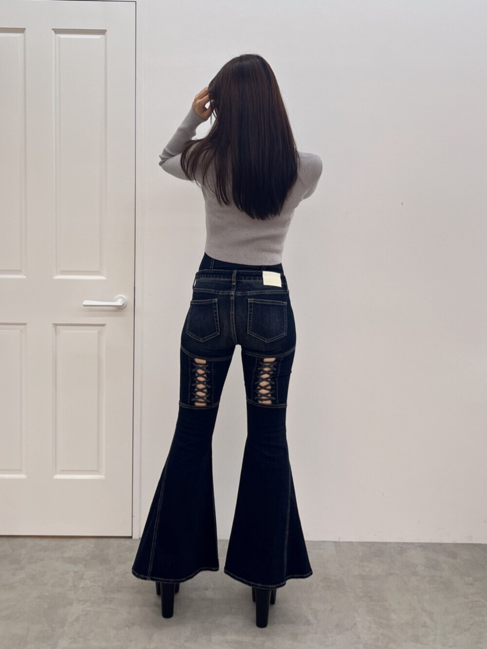 ブラック系のブーツ、シルバー系のニット/セーター、ブルー系のデニムパンツを着用したレディースの秋コーディネートの3枚目の写真