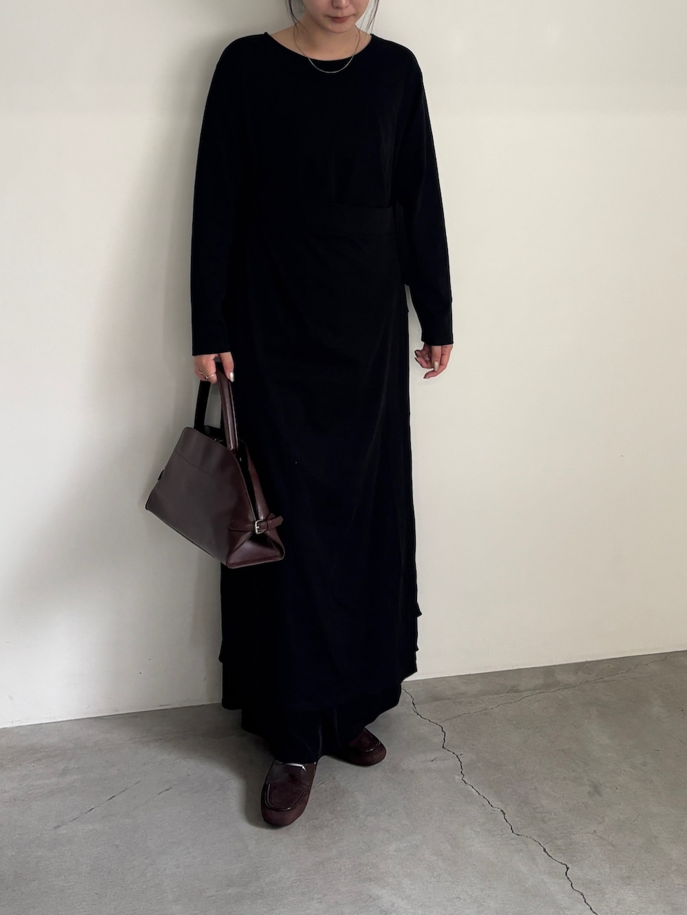 ブラック系のワンピース、ブラック系のスカート、ブラウン系のローファーを着用したレディースの秋コーディネートの2枚目の写真