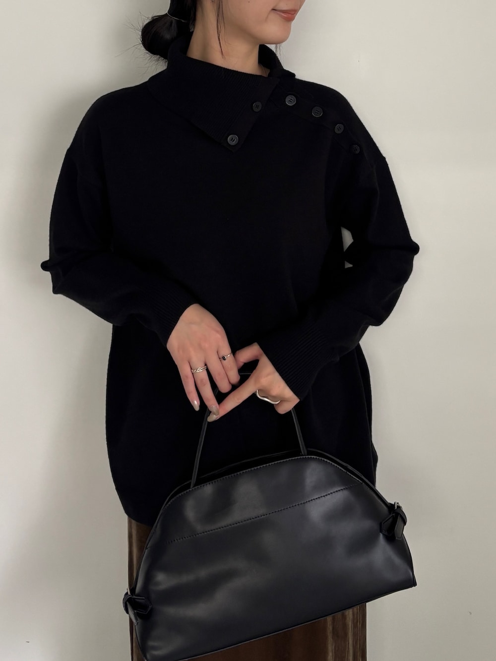 グリーン系のスカート、ブラック系のローファー、ブラック系のニット/セーターを着用したレディースの秋コーディネートの2枚目の写真