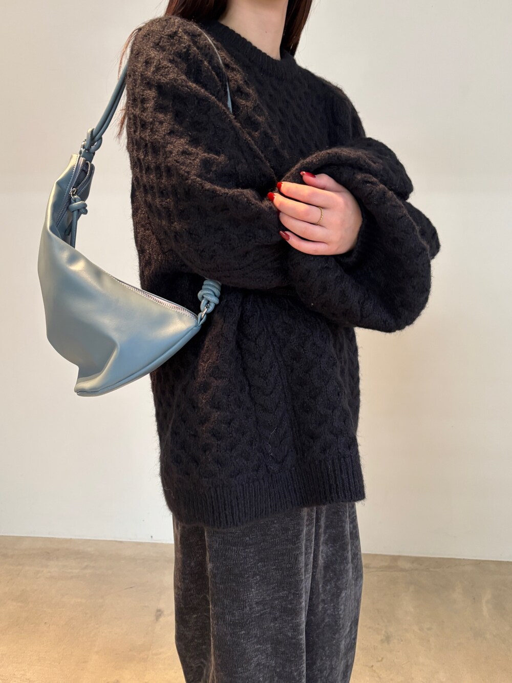 グレー系のその他パンツ、ブラック系のニット/セーター、ブラック系のショルダーバッグを着用したレディースの冬コーディネートの2枚目の写真