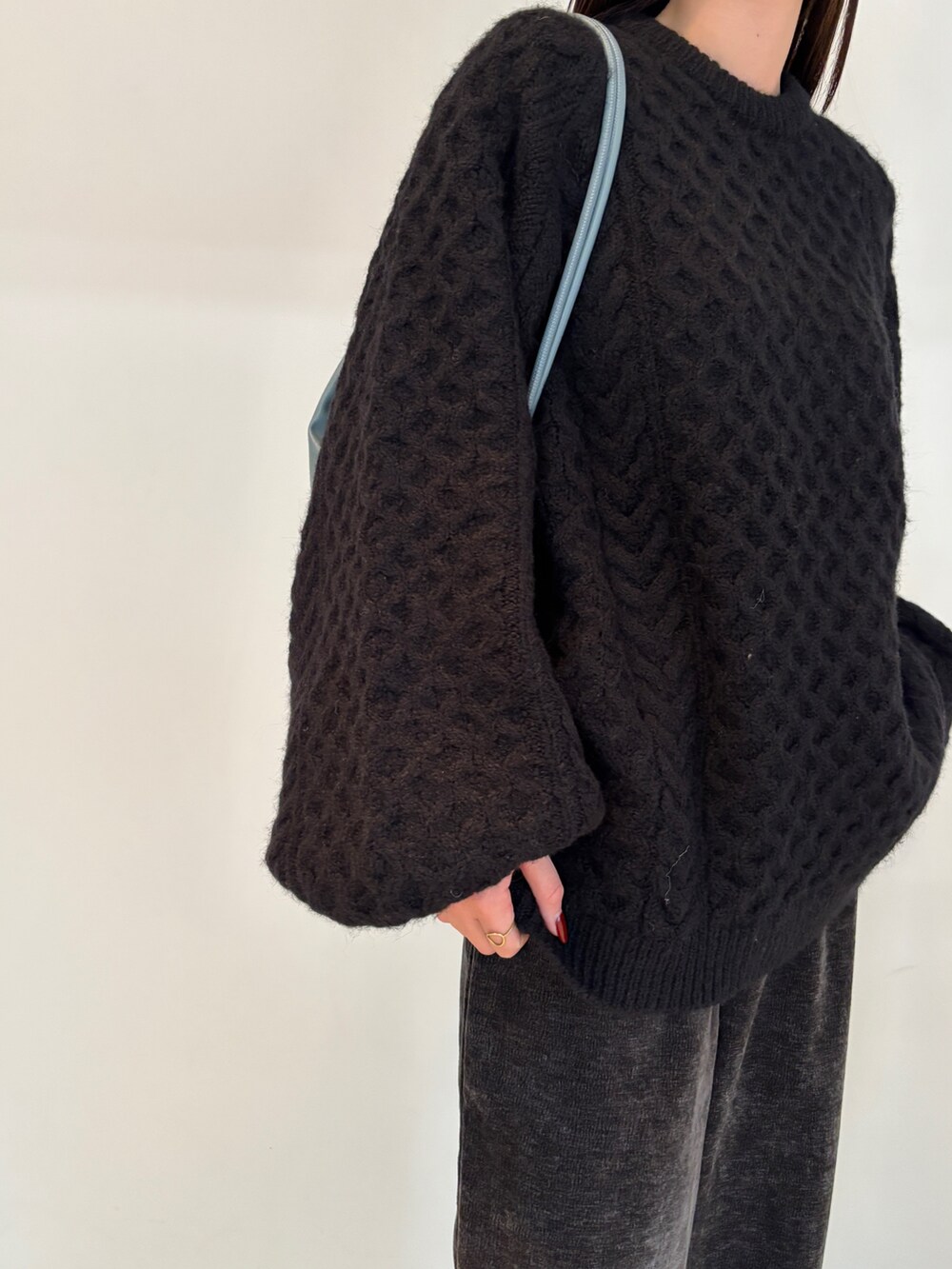 グレー系のその他パンツ、ブラック系のニット/セーター、ブラック系のショルダーバッグを着用したレディースの冬コーディネートの3枚目の写真
