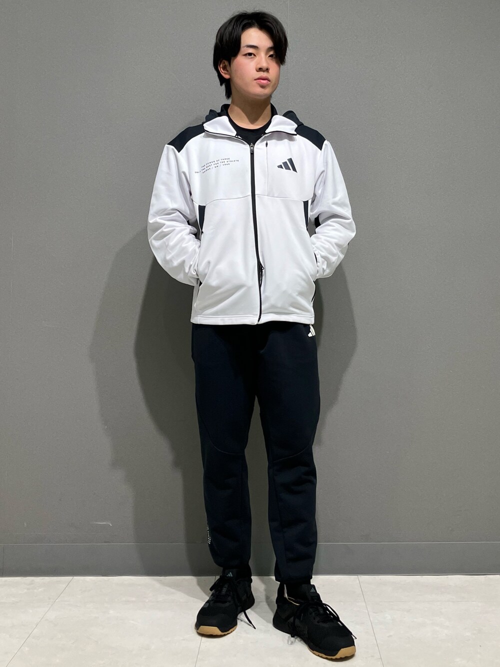 ホワイト系のパーカー、ブラック系のスウェットパンツ、ブラック系のスニーカーを着用したメンズの冬コーディネートの2枚目の写真