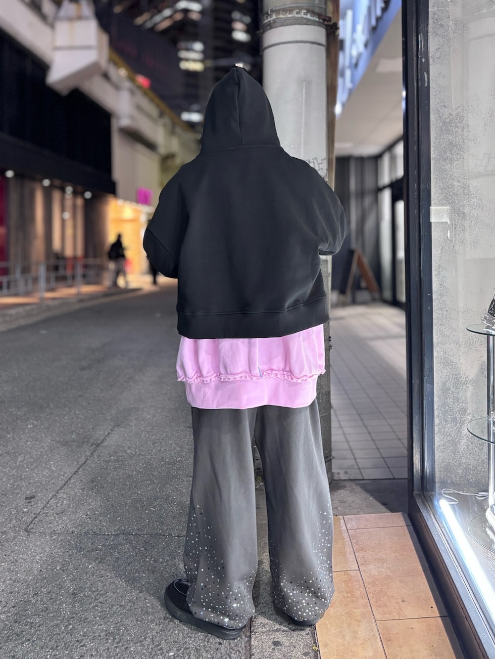 ブラック系のパーカー、ブラウン系のスウェットパンツ、ピンク系のスウェットを着用したメンズの冬コーディネートの2枚目の写真