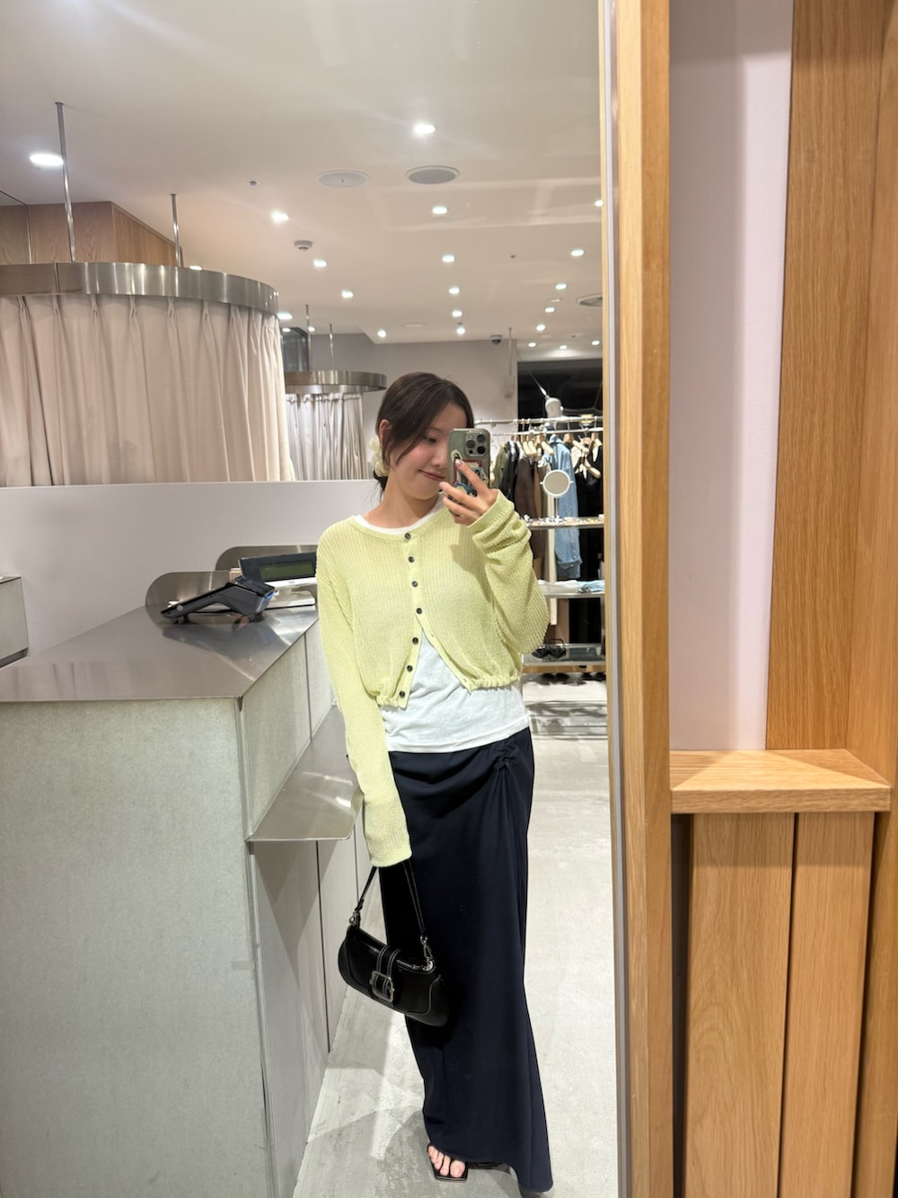 イエロー系のカーディガン/ボレロ、ホワイト系のTシャツ/カットソー、ブルー系のスカートを着用したレディースの春コーディネートの2枚目の写真