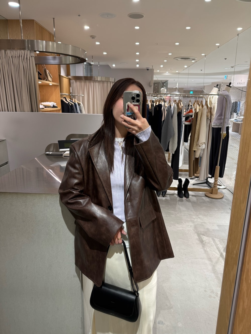 ブラウン系のテーラードジャケット、ホワイト系のTシャツ/カットソー、ホワイト系のスカートを着用したレディースの冬コーディネートの2枚目の写真