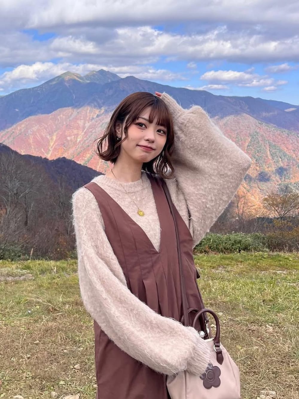 ベージュ系のトートバッグを着用したレディースの秋コーディネートの2枚目の写真