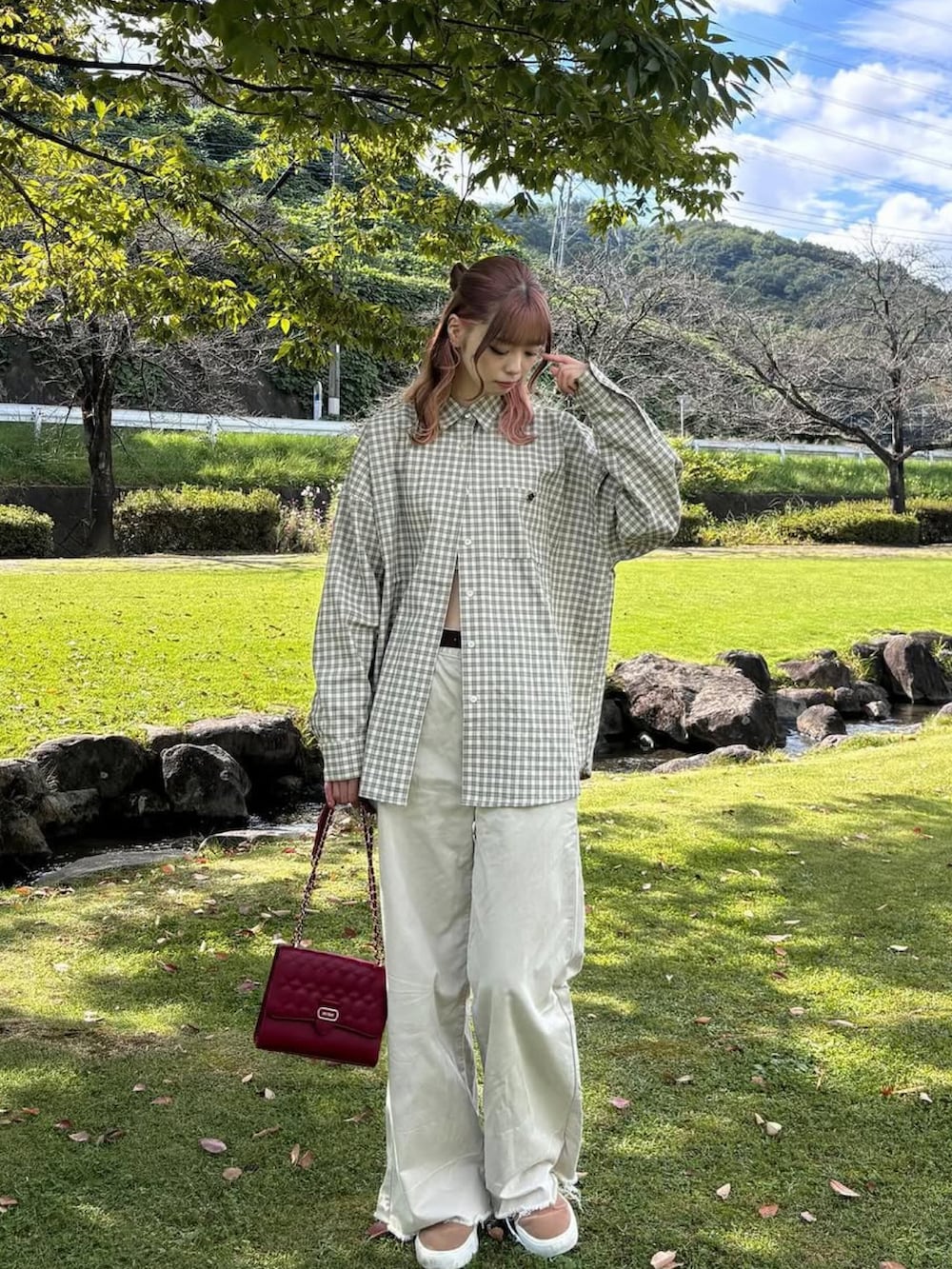 ベージュ系のパンツ、レッド系のバッグ、ベージュ系のジャケット/アウターを着用したレディースの春コーディネートの2枚目の写真