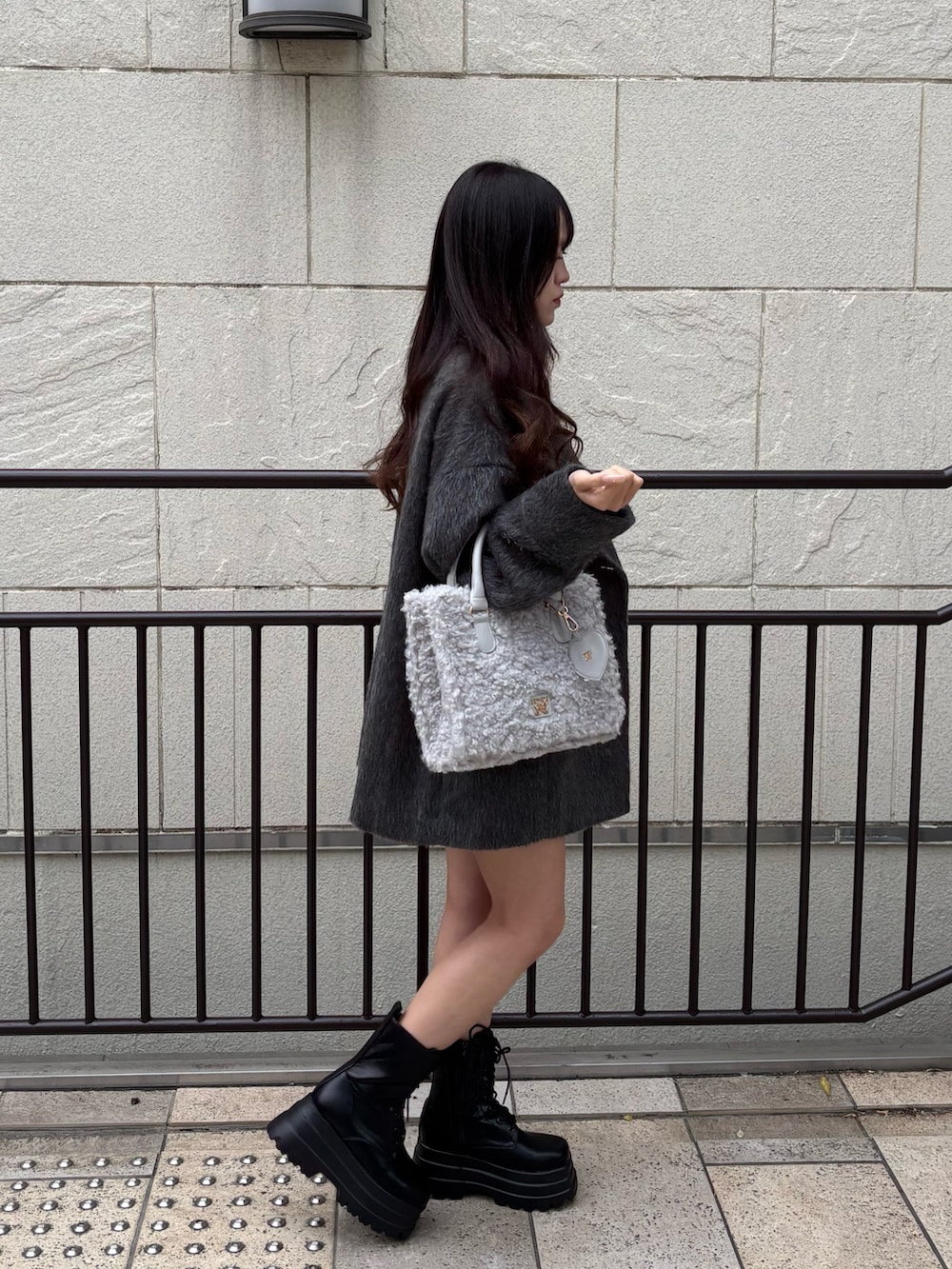 ブラック系のワンピース、グレー系のその他アウター、ブラック系のブーツを着用したレディースの秋コーディネートの3枚目の写真