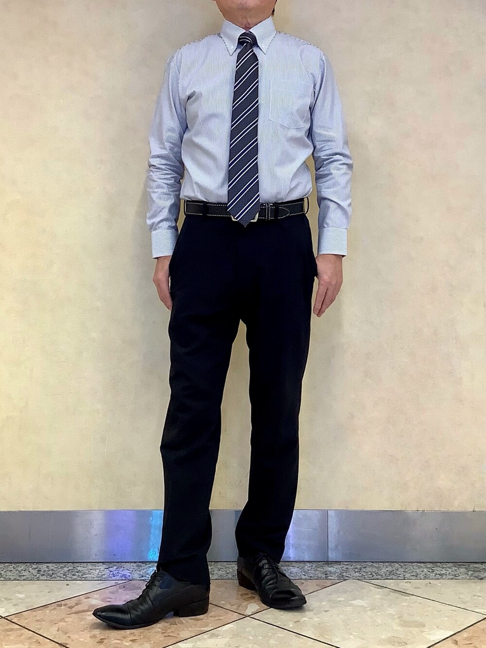 ブルー系のビジネスシャツ、グレー系のベストを着用したメンズの冬コーディネートの3枚目の写真