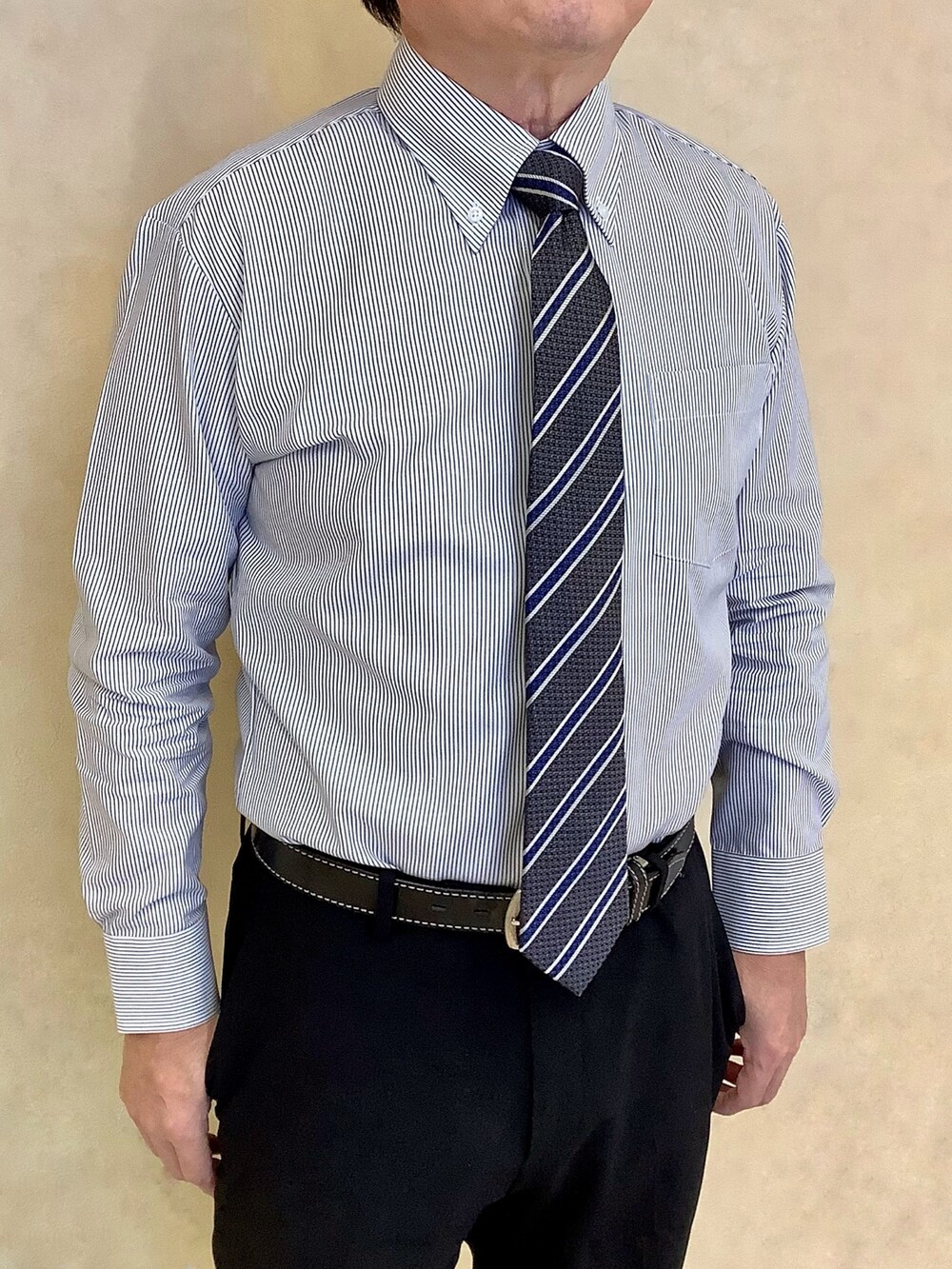 ブルー系のビジネスシャツ、グレー系のベストを着用したメンズの冬コーディネートの2枚目の写真