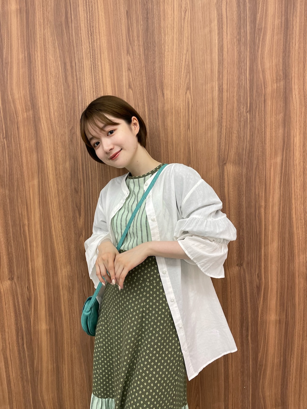 ホワイト系のシャツ/ブラウス、ブラウン系のサンダル、グリーン系のワンピースを着用したレディースの夏コーディネートの2枚目の写真