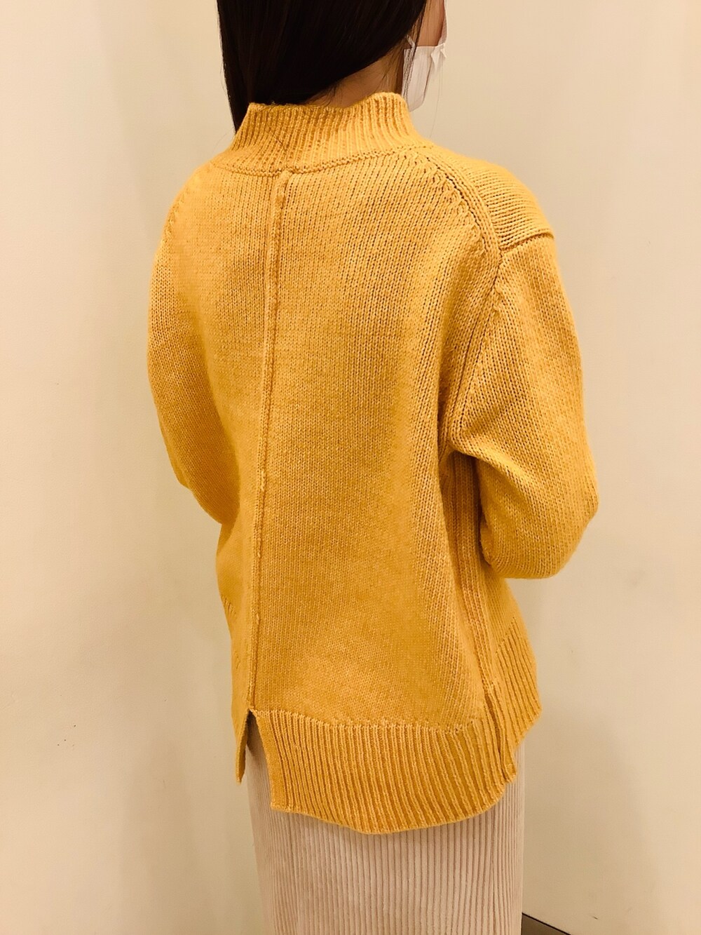 イエロー系のニット/セーターを着用したレディースの冬コーディネートの3枚目の写真