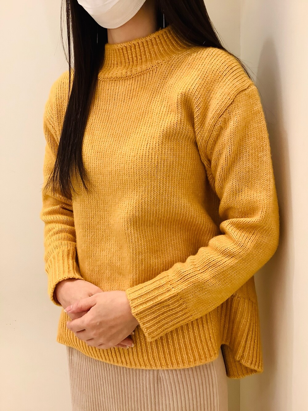 イエロー系のニット/セーターを着用したレディースの冬コーディネートの2枚目の写真