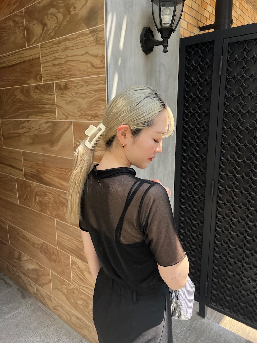 ブラック系のTシャツ/カットソー、ブラック系のスカート、シルバー系のハンドバッグを着用したレディースの夏コーディネートの4枚目の写真