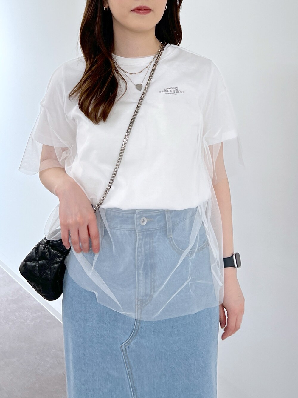 ホワイト系のTシャツ/カットソー、ブルー系のデニムスカート、ブラック系のショルダーバッグを着用したレディースの夏コーディネートの3枚目の写真