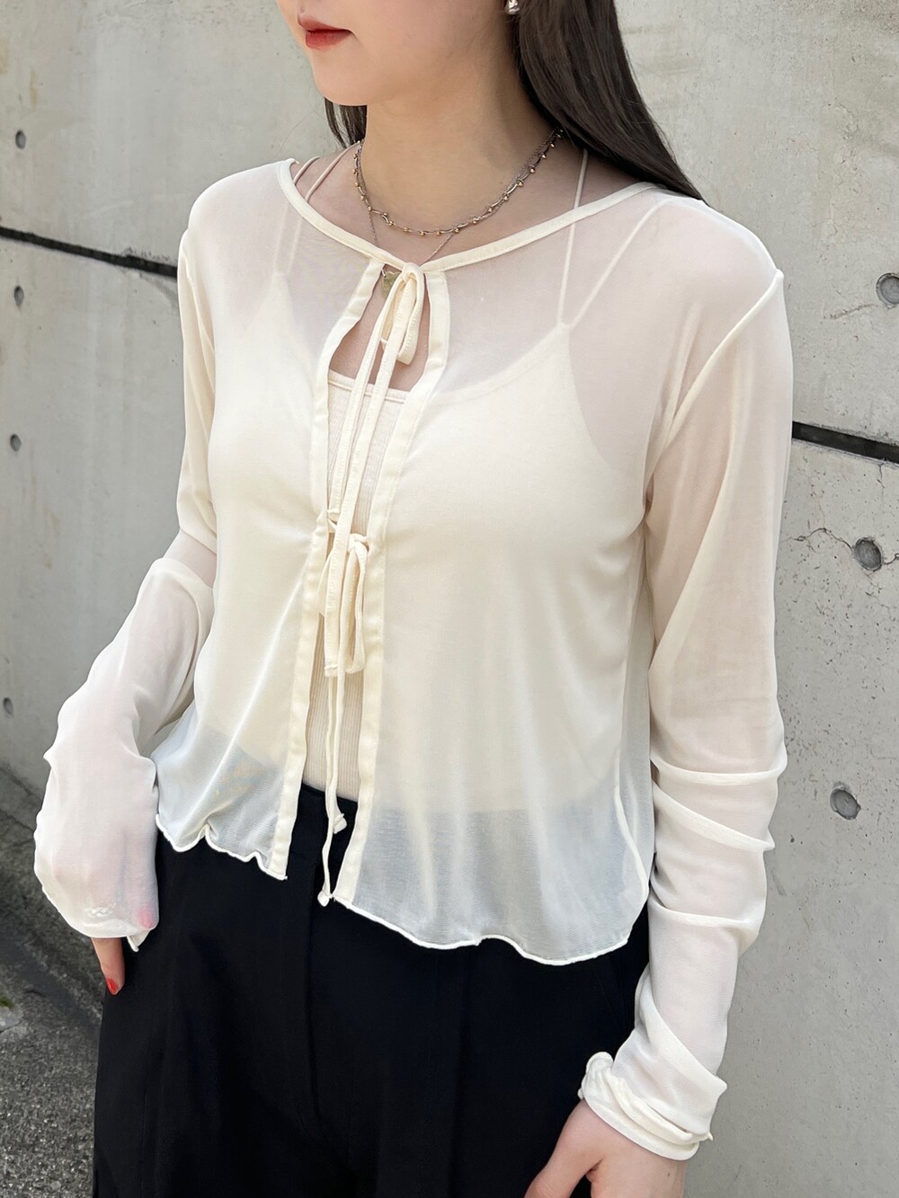 ブラック系のカーゴパンツ、ホワイト系のカーディガン/ボレロ、ホワイト系のキャミソールを着用したレディースの夏コーディネートの3枚目の写真