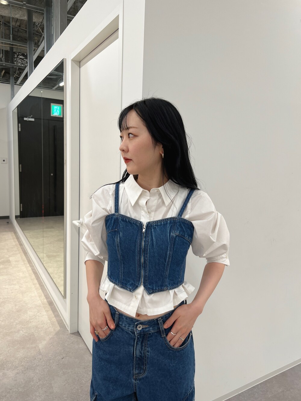 ブルー系のベスト、ブルー系のデニムパンツ、ホワイト系のシャツ/ブラウスを着用したレディースの夏コーディネートの2枚目の写真