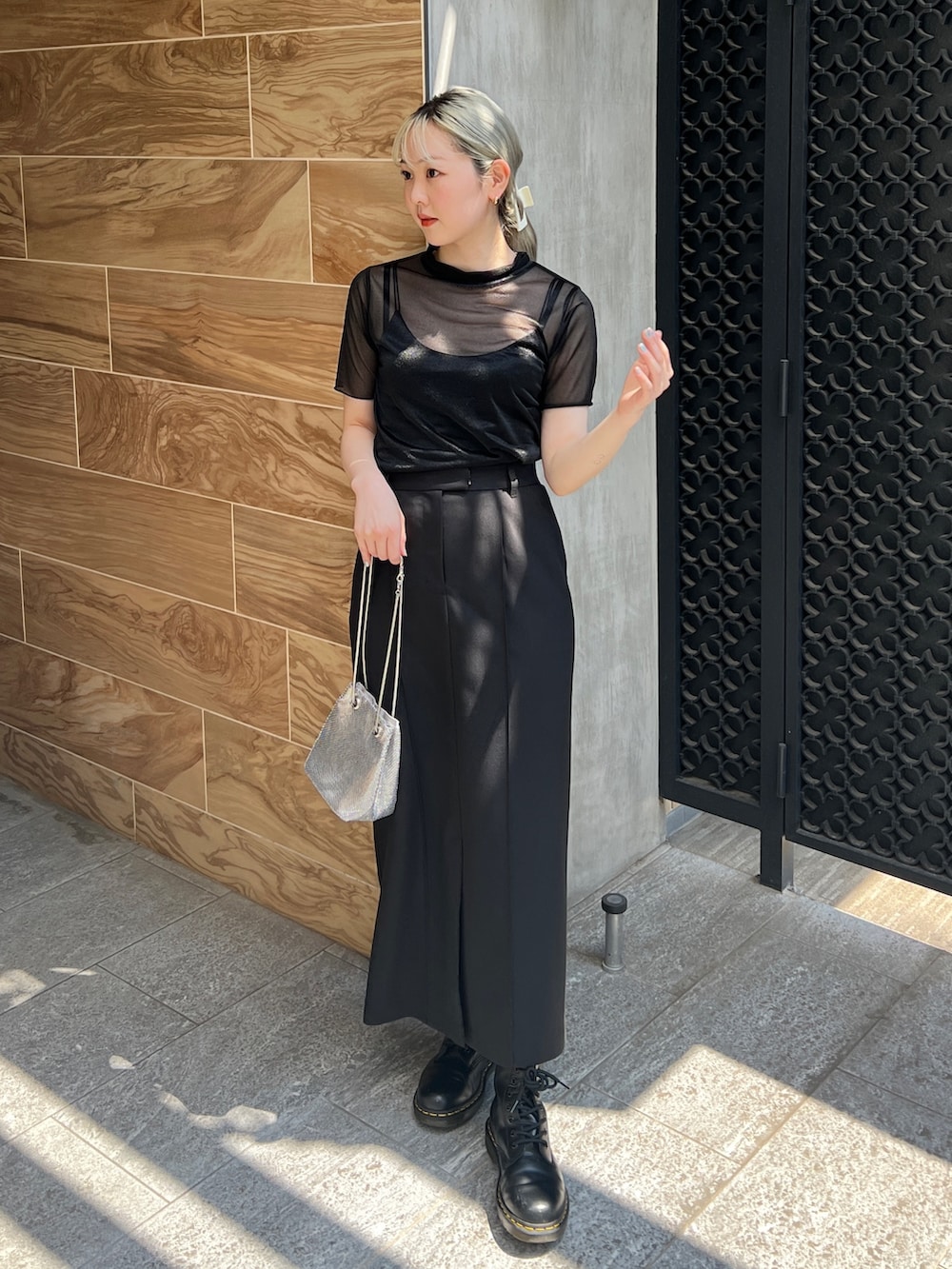 ブラック系のTシャツ/カットソー、ブラック系のスカート、シルバー系のハンドバッグを着用したレディースの夏コーディネートの2枚目の写真