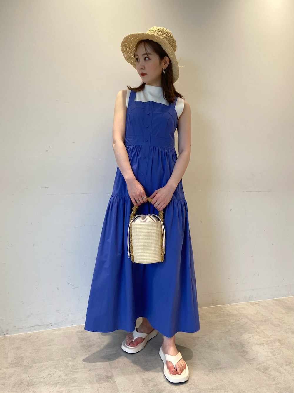ブルー系のワンピース、ホワイト系のサンダル、ベージュ系のハットを着用したレディースの夏コーディネートの3枚目の写真