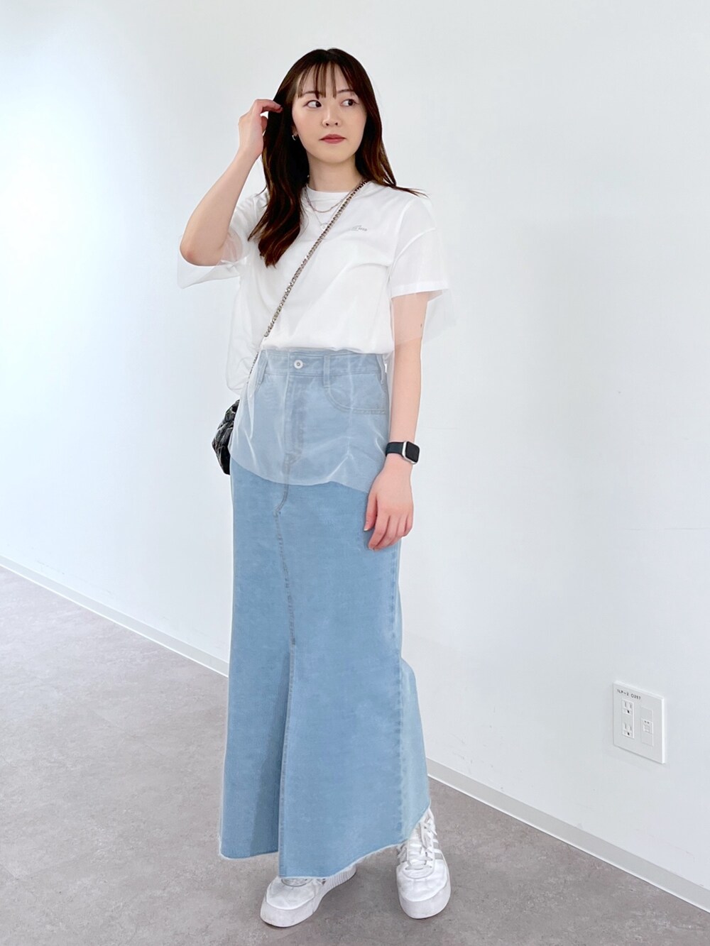 ホワイト系のTシャツ/カットソー、ブルー系のデニムスカート、ブラック系のショルダーバッグを着用したレディースの夏コーディネートの2枚目の写真