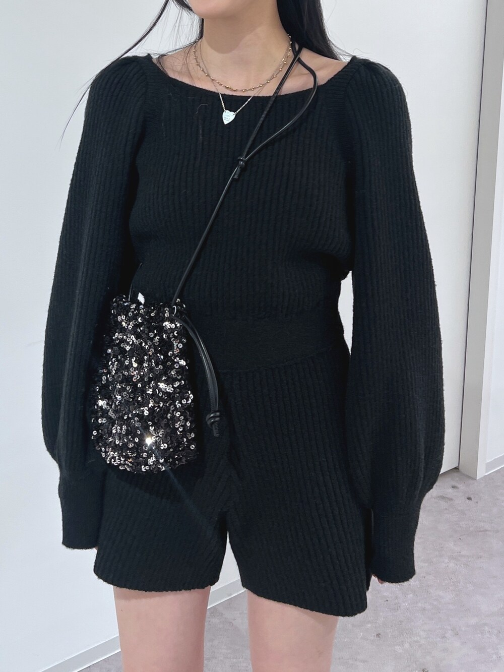 ブラック系のワンピース、ブラック系のハンドバッグを着用したレディースの冬コーディネートの3枚目の写真