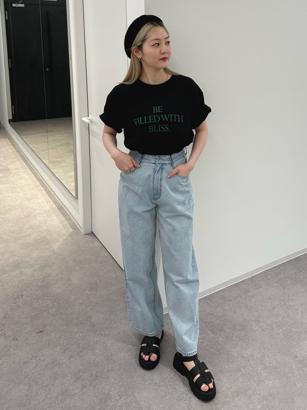 ブラック系のTシャツ/カットソー、ブルー系のデニムパンツ、ブラック系のサンダルを着用したレディースの春コーディネートの2枚目の写真