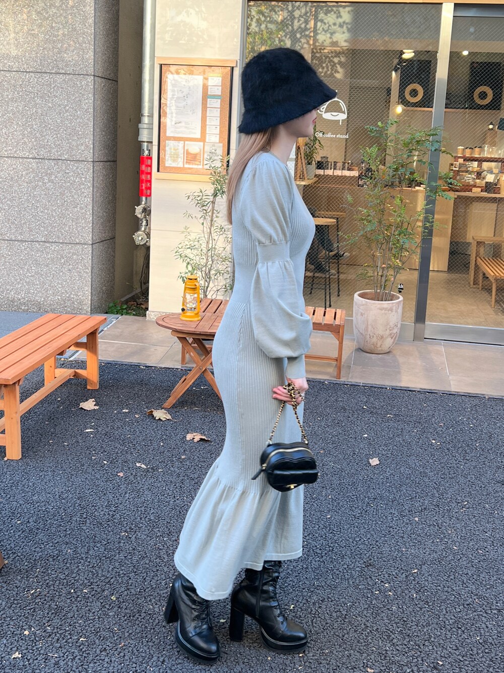 グリーン系のワンピース、ブラック系のショルダーバッグ、ブラック系のハットを着用したレディースの冬コーディネートの3枚目の写真